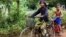 Im Chaem, a former Khmer Rouge cadre, is riding a bike along with her grandson in Anlong Veng, in Oddar Meanchey province in Cambodia, Sunday April 23, 2017. (Sun Narin/VOA Khmer)