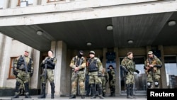 亲俄罗斯的武装分子4月14日站在乌克兰东部的斯洛文斯克的市长办公室外