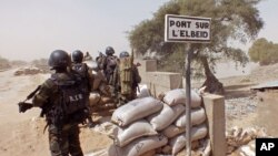 Passers-by look at fish swimming in a large glass tank displayed at Ginza shopping district in Tokyo, Japan.