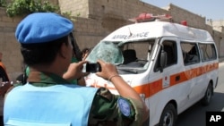 یک ناظر سازمان ملل در حال عکسبرداری از آمبولانسی که توسط بمب گذاری منفجر شد