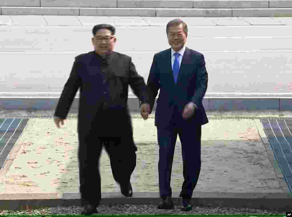 Le dirigeant nord-coréen Kim Jong Un, traverse la frontière de la Corée du Sud, ainsi que le président sud-coréen Moon Jae-in à Panmunjom pour leurs tête-à-tête, le 27 avril 2017.
