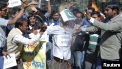 Activists of the youth wing of India's ruling Congress party shout slogans as they beat and burn an effigy depicting Pakistan during a protest in the central Indian city of Bhopal, January 9, 2013.