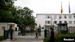 资料照片：2022年8月8日，一名男子走过缅甸驻北京大使馆外站岗的武警士兵。（路透社照片）