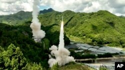 中国电视节目截屏，画面字幕：东部战区火箭军部队对台岛东部外海预定海域实施常导火力突击 全部精准命中目标。-美联社提供照片