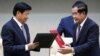 Laos' Prime Minister Thongloun Sisoulith (L) exchanges documents with his Cambodian counterpart Hun Sen after a signing ceremony at the Peace Palace in Phnom Penh, Cambodia, September 12, 2019.