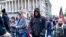 A man (center in black coat) identified by U.S. federal prosecutors as Shane Jason Woods of Auburn, Illinois. is seen in a frame grab from video shot during the Jan. 6, 2021 assault on the U.S. Capitol, moments before attacking members of the news media. 