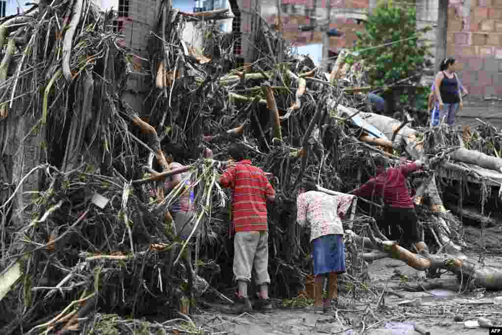 Residents search for their missing relatives in the rubble of a house destroyed by a landslide during heavy rains in Las Tejerias, Aragua state, Venezuela, Oct. 9, 2022.&nbsp;&nbsp;A landslide in central Venezuela left at least 22 people dead and more than 50 missing after heavy rains caused a river to overflow, Vice President Delcy Rodriguez said.&nbsp;