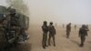 FILE - Cameroonian soldiers from the Rapid Intervention Brigade stand guard amidst dust kicked up by a helicopter in Kolofata, Cameroon, March 16, 2016. 