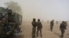 FILE - Cameroonian soldiers from the Rapid Intervention Brigade stand guard amidst dust kicked up by a helicopter in Kolofata, Cameroon, March 16, 2016. 