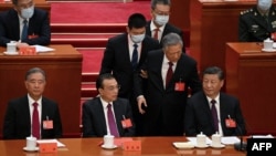 2022年10月22日，在北京人民大会堂举行的中共二十大闭幕式上，前中共总书记胡锦涛被警卫扶着离席。