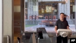 马斯克搬着一个洗手池盆进入在旧金山的推特总部。（2022年10月26日）