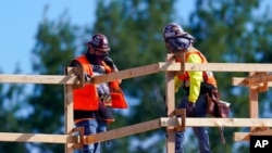 FILE - Construction workers talk at a USA Properties Fund site, Feb. 2, 2021, in Simi Valley, Calif. A U.S. government jobs report June 4, 2021, said unemployment fell, but signs remain that employers are finding some jobs hard to fill.