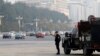 A Chinese policeman of the Special Weapons and Tactics (SWAT) team stands guard on a main street next to Tiananmen Square in Beijing, Oct. 31, 2013.