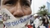 In this photo taken on Nov. 16, 2012, a Cambodian protester tapes his mouth shut in protest against discrimination of the Lesbian, Gay, Bisexual and Transgender (LGBT), in front of National Assembly, in Phnom Penh, Cambodia. 