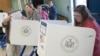 FILE - Voters stand behind ballot booths to cast their votes during the U.S. presidential election at a polling station in the Staten Island Borough of New York, November 6, 2012.