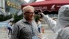 A man gets his temperature check before entering the Canton Fair, China’s largest trade show, in Guangzhou, Guangdong province, Oct. 23, 2014.