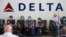 미국 유타주 솔트레이크시티 국제공항 내 델타항공 표지 앞에 마스크를 쓴 여행객들이 앉아있다. (자료사진)