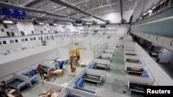 工人们正在把长春的一个展览中心改造成拥有1500张床位的临时医院。