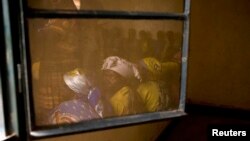 Members of Congolese Women's Association, who have been widowed by conflict, are reflected in a window during their meeting in the town of Rutshuru in North Kivu, east of the Democratic Republic of Congo, May 2012.