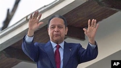 Former dictator Jean-Claude 'Baby Doc' Duvalier waves to supporters from the balcony of a rented guest house where he is staying in Port-au-Prince, Haiti, January 21, 2011.
