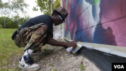 Eric Ricks painting a mural, Takoma, D.C., Sept., 2014, (M. Kornely/VOA)