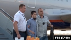 RUSSIA -- A Tatarstan-born Russian national (born in 1988, center), who has been extradited by Greece to Russia, is escorted at an airport in the Moscow region, August 30, 2018