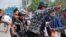 FILE - A man with a head injury is carried by fellow demonstrators during an anti-coup protest in Mandalay, Myanmar, March 22, 2021.