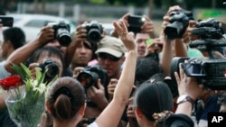 Seorang perempuan mengacungkan tiga jari salam seperti tanda salut pada film "The Hunger Games" dalam sebuah demonstrasi antikudeta di luar Kedubes Australia di Bangkok, 4/6/2014