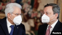 Italian President Sergio Mattarella and Prime Minister Mario Draghi wearing face masks speak after the new cabinet ministers swearing-in ceremony, at the Quirinale Presidential Palace in Rome, Italy, Feb. 13, 2021. 