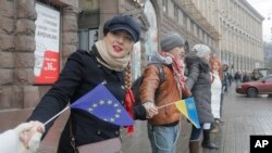 Para pengunjuk rasa berpegangan tangan membentuk rantai manusia sebagai simbol integrasi terhadap Uni Eropa dalam demonstrasi di Kiev, Ukraina, 29/11/2013.