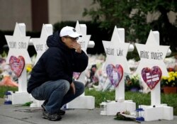 FILE - A person pauses in front of Stars of David with the names of those killed in a deadly shooting at the Tree of Life Synagogue, in Pittsburgh, Oct. 29, 2018.