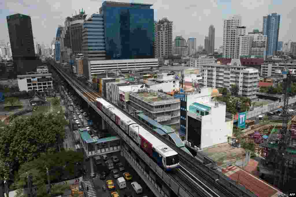 Sebuah kereta api melaju sepanjang jalur kereta api di Bangkok, Thailand. Kabinet Thailand menyetujui anggaran 68 milyar dolar untuk pembangunan kereta api cepat dan sistem transportasi modern di Thailand.