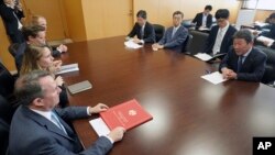 FILE - Britain's Secretary of State for International Trade Liam Fox, bottom left, and Japanese Minister of Economic Revitalization Toshimitsu Motegi, right, attend a meeting in Tokyo July 31, 2018. (AP Photo/Eugene Hoshiko)