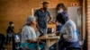 FILE - People are processed before receiving their COVID-19 vaccinations at the Orange Farm, South Africa, multipurpose center, Dec. 3, 2021.