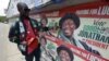 A man points to campaign posters of Nigerian President Goodluck Jonathan and candidate of the ruling People's Democratic Party (PDP) in Lagos, March 21, 2015. 