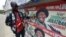 A man points to campaign posters of Nigerian President Goodluck Jonathan and candidate of the ruling People's Democratic Party (PDP) in Lagos, March 21, 2015. 