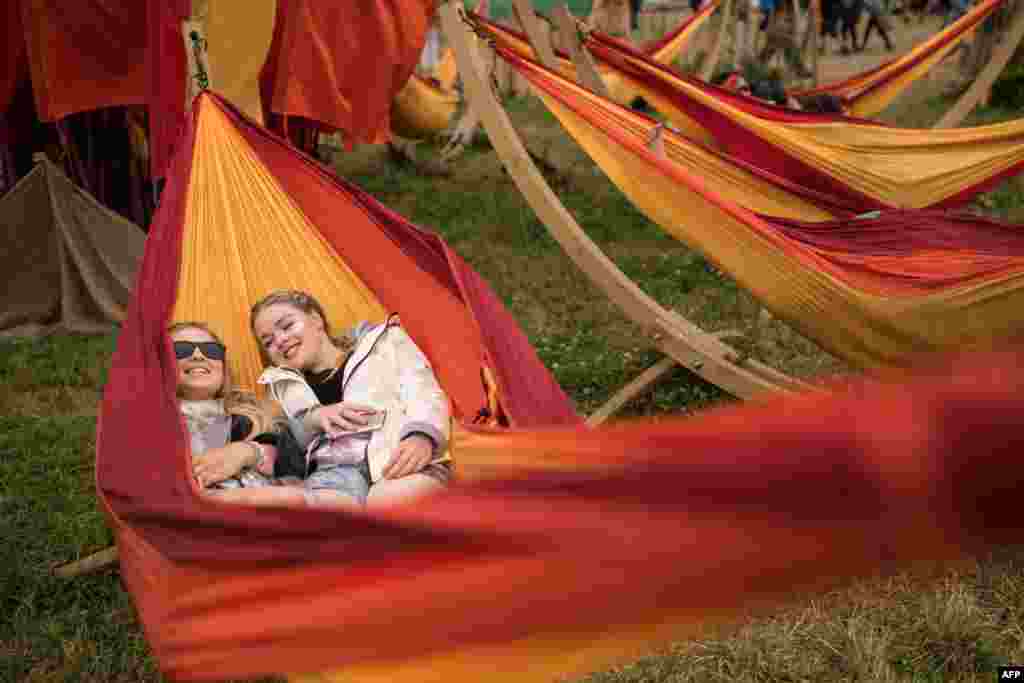Festival-goers relax in a hammock at the Glastonbury Festival of Music and Performing Arts on Worthy Farm near the village of Pilton in Somerset, south-west England.