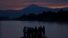 Central American migrants stand on a raft to cross the Suchiate River from Guatemala to Mexico, as the Tacana volcano stands tall near Ciudad Hidalgo, Mexico, early Monday, June 10, 2019. Mexican and U.S. officials reached an accord late Friday that…