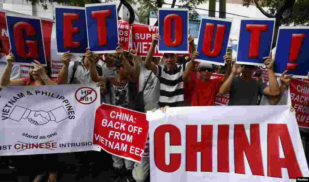 Aktivis berkewarganegaraan Filipina dan Vietnam membawa poster dan meneriakkan slogan-slogan anti-China sambil berjalan di luar konsulat China di distrik keuangan Makati di Manila, 16 Mei 2014.