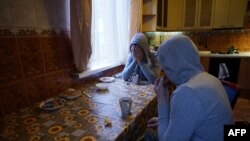 Chechen gay men who fled persecution in their home Russia's Muslim region of Chechnya due to his sexual-orientation, sits around a table in their flat in Moscow on April 17, 2017. / AFP PHOTO / Naira DAVLASHYAN / TO GO WITH AFP STORY BY Anais LLOBET