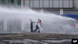 Protesters are sprayed with water canon during clashes with riot police in Istanbul, Turkey, June 22, 2013