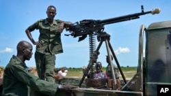 FILE - Government soldiers stand guard by their vehicle on the front lines in the town of Kuek, northern Upper Nile state, South Sudan, Aug. 19, 2017