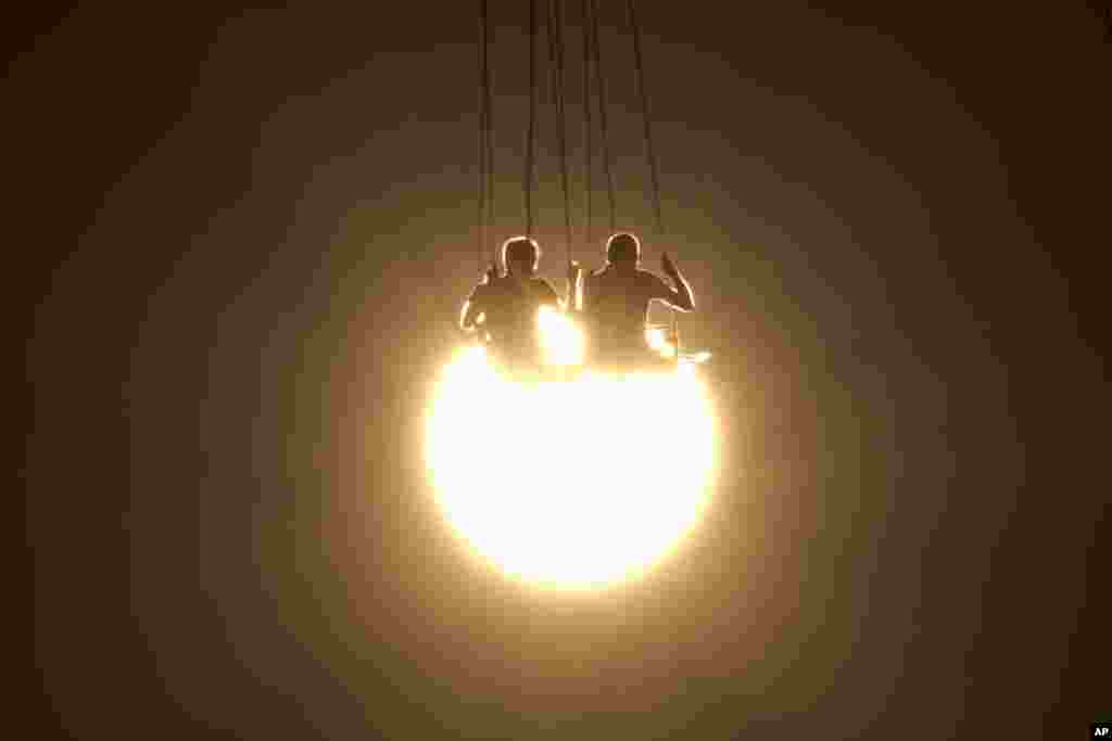 មនុស្ស​ពីរ​នាក់​សប្បាយ​រីករាយ​ជាមួយ​នឹង​ការ​ជិះទោង​ ខណៈ​ពេល​ថ្ងៃលិច​នៅ​សួនកម្សាន្ត​មួយ​ ក្រុង​អាថែន ប្រទេស​ក្រិក កាល​ពី​ថ្ងៃ​ទី២៩ ខែ​មិថុនា ឆ្នាំ​២០១៦។&nbsp;