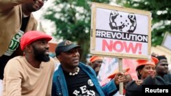 Nigerian activist and former presidential candidate Omoyele Sowore sits with activists during a protest over fuel and power price rises, near the U.S. embassy in Abuja, Nigeria, Oct. 1, 2020.
