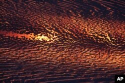 In this photo provided by the U.S. Geological Survey, lava from Kilauea volcano flows from the Leilani Estates neighborhood, July 17, 2018 near Pahoa, Hawaii.