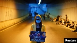 一位抗议者举着一名被打伤的抗议者的图片，要求香港特首林郑月娥辞职以及香港政府撤回《逃犯条例》修订方案。(2019年6月17日)