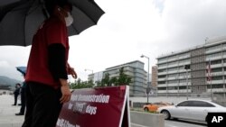 A man stands with a banner to oppose the joint military exercises between South Korea and the United States near the U.S. Embassy in Seoul, South Korea, Sunday, Aug. 16, 2020. The countries will begin their annual joint military exercises this week,…