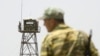 FILE - A frontier guard stands on a bridge to Afghanistan across Panj river in Panji Poyon border outpost, south of Dushanbe, Tajikistan, May 31, 2008. 