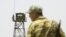 FILE - A frontier guard stands on a bridge to Afghanistan across Panj river in Panji Poyon border outpost, south of Dushanbe, Tajikistan, May 31, 2008. 