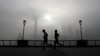 FILE - People jog past the Pudong Financial District shrouded in fog and pollution at the Shanghai Bund in Shanghai, China, Thursday, April 14, 2016. Air pollution has caused 5.5 million premature deaths globally in 2013, outpacing disease, a new study has found.
